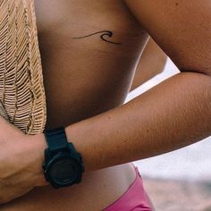 a woman with a tattoo on her chest holding a straw hat