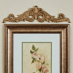 an ornate gold frame holds a painting of pink roses