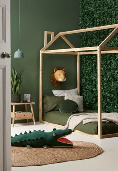 a green bedroom with a bed and an animal head on the wall next to it