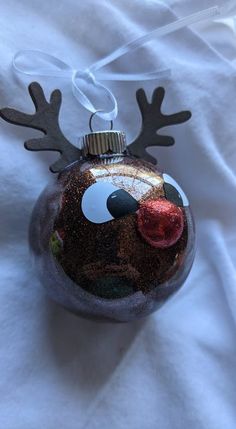 a glass ornament with reindeer's nose and antlers on it