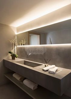 a bathroom with a sink, mirror and flowers in the vase on the counter top