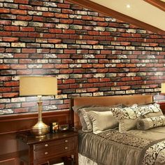 a bedroom with a brick wall and bed in the corner, along with two lamps on either side of the bed