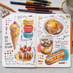 an open notebook with food illustrations on the pages and colored pencils next to it