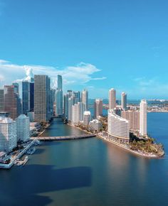 an aerial view of a large city with tall buildings in the background and water surrounding it