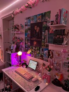 a desk with a computer, keyboard and mouse on it in a room filled with posters