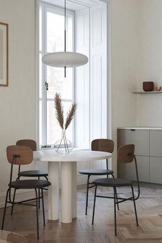 a white table with four chairs around it in a room next to a bathtub