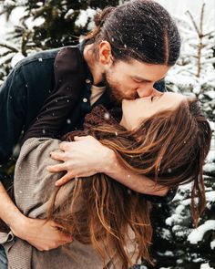 a man and woman kissing in the snow