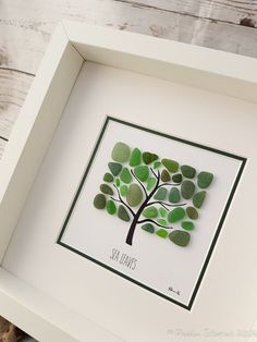 a white frame with a green tree cut out of it's leaves in the center