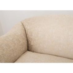 a beige couch sitting next to a white wall