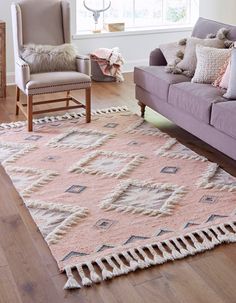 a living room filled with furniture and a pink rug