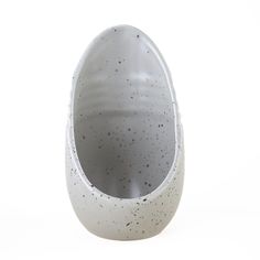 an egg shaped vase sitting on top of a white table