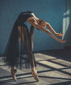 a woman is dancing on the floor with her legs spread out and one leg bent