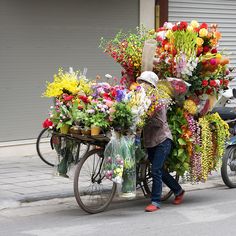 a person pushing a bike with flowers on the back