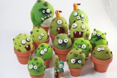 a group of green plants with googly eyes and mouths on them, all in clay pots