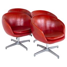 two red leather chairs sitting next to each other on top of a white flooring