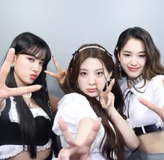 three young women posing for the camera with their hands in the shape of peace signs