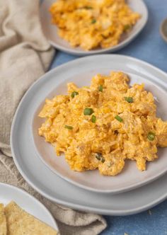 two plates with scrambled eggs and tortilla chips