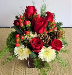 a vase filled with red roses and white flowers