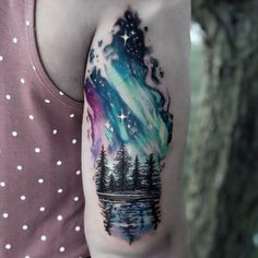 a man with a tattoo on his arm has an aurora bore in the sky and trees