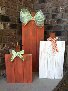 three wooden boxes with bows on them sitting in front of a brick wall and door