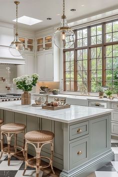 a large kitchen with an island in the middle and three stools at the end