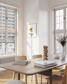 a dining room table and chairs in front of two windows