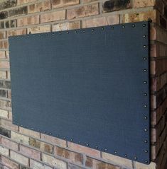 a blue sign mounted to the side of a brick wall with rivets on it