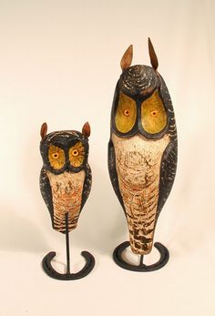 two owl figurines sitting next to each other on top of a white surface