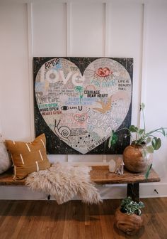 a wooden bench sitting in front of a heart shaped painting