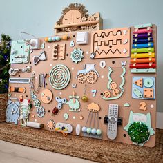 a wooden board covered in lots of different items on top of a table next to a christmas tree