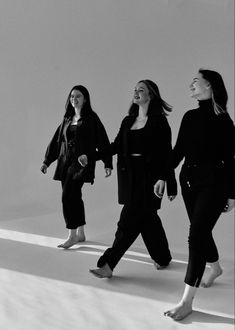 three women walking down the street in black and white