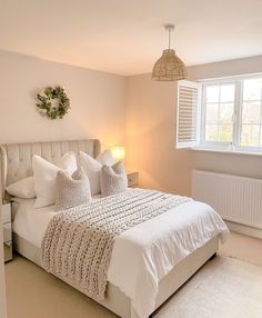 a white bed sitting next to a window in a bedroom