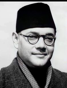 a black and white photo of a man wearing glasses, a hat and a jacket