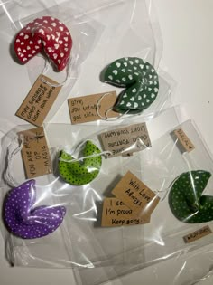 several different colored polka dot hair clips on a plastic bag with some tags attached to them