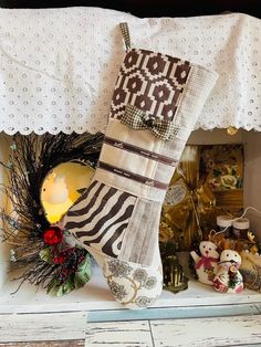 a stocking hanging on the mantle with christmas decorations