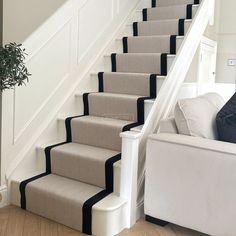 a white couch sitting next to a set of stairs