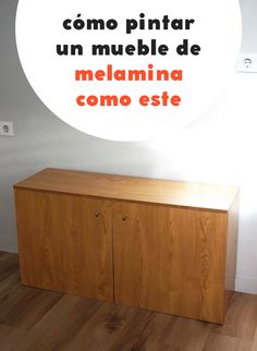 a wooden cabinet sitting on top of a hard wood floor next to a white wall