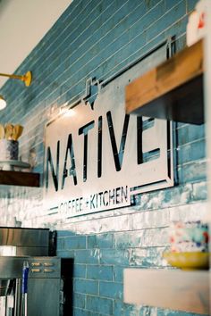 the sign for native coffee kitchen is hanging on the brick wall above the stovetop