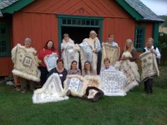 a group of people holding up blankets in front of a red building