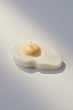 an egg shell with a candle in the middle on a white surface, as seen from above