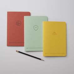 four notebooks lined up next to each other with a pencil in front of them