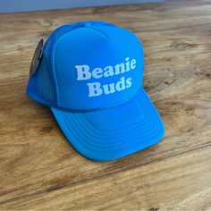 Beanie Buds Graphic Bright Blue Color Adjustable Terry Band On Interior Of Hat Trucker Style Designed By Rad Hats Los Angeles Spring Blue Trucker Hat With Letter Print, Trendy Blue Snapback Hat, One Size Fits Most, Blue Trucker Snapback Hat For Beach, Blue Letter Print Trucker Hat For Beach, Blue Snapback Hat With Letter Print, Blue Letter Print Snapback Hat, Blue Baseball Cap One Size Fits Most, Blue Trucker Hat With Letter Print And Curved Brim, Blue Letter Print Hat For The Beach