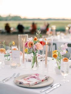 the table is set with flowers and candles