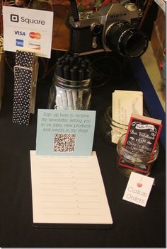 a table with various items on it including a camera, notepad and pen holder