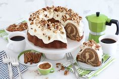 a bundt cake with white frosting and pecans on top, surrounded by other desserts