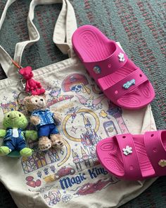 two teddy bears are sitting on top of a tote bag and some other items