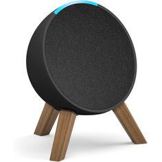 an amazon echo speaker sitting on top of a wooden stand with a blue light in the center