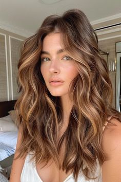 Woman with long, wavy brown hair and subtle highlights standing indoors. Brown Balayage Caramel Honey, Perfect Fall Hair Color, Balayage Hair Warm Tones, Bronde Caramel Hair, Clear Spring Hair Color Ideas, Salted Caramel Balayage, Sunkissed Brown Balayage, Burnett Baylage Fall, Hair Ideas Pale Skin