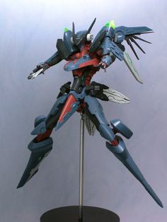 an action figure is posed on top of a stand, with wings spread out to the side