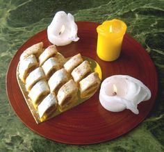 there is a plate with pastries on it and candles in the middle, along with one candle